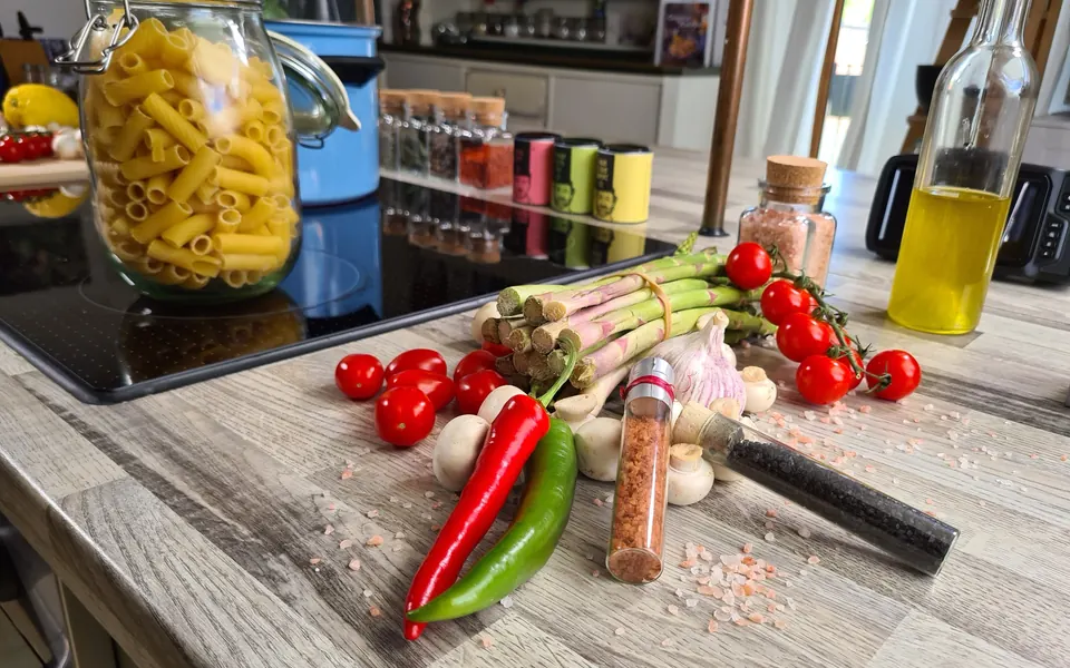 Pasta, Spargel, Tomaten und weitere Zutaten auf der Küchenarbeitsplatte