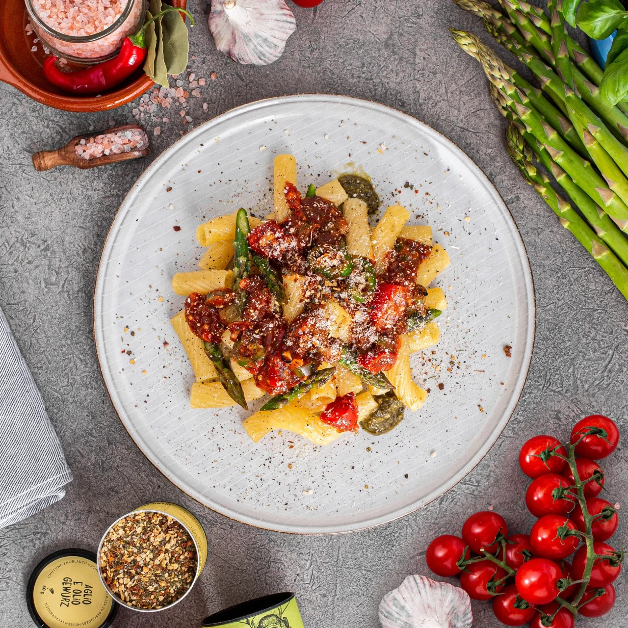 Pasta mit Tomaten und grünem Spargel, von oben fotografiert, zwischen Zutaten und Just-Spices-Gewürzen