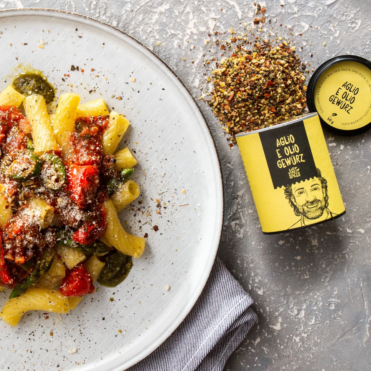 Nahaufnahme von Pasta neben einem geöffneten Just-Spices-Gewürz und verstreuten Gewürzen